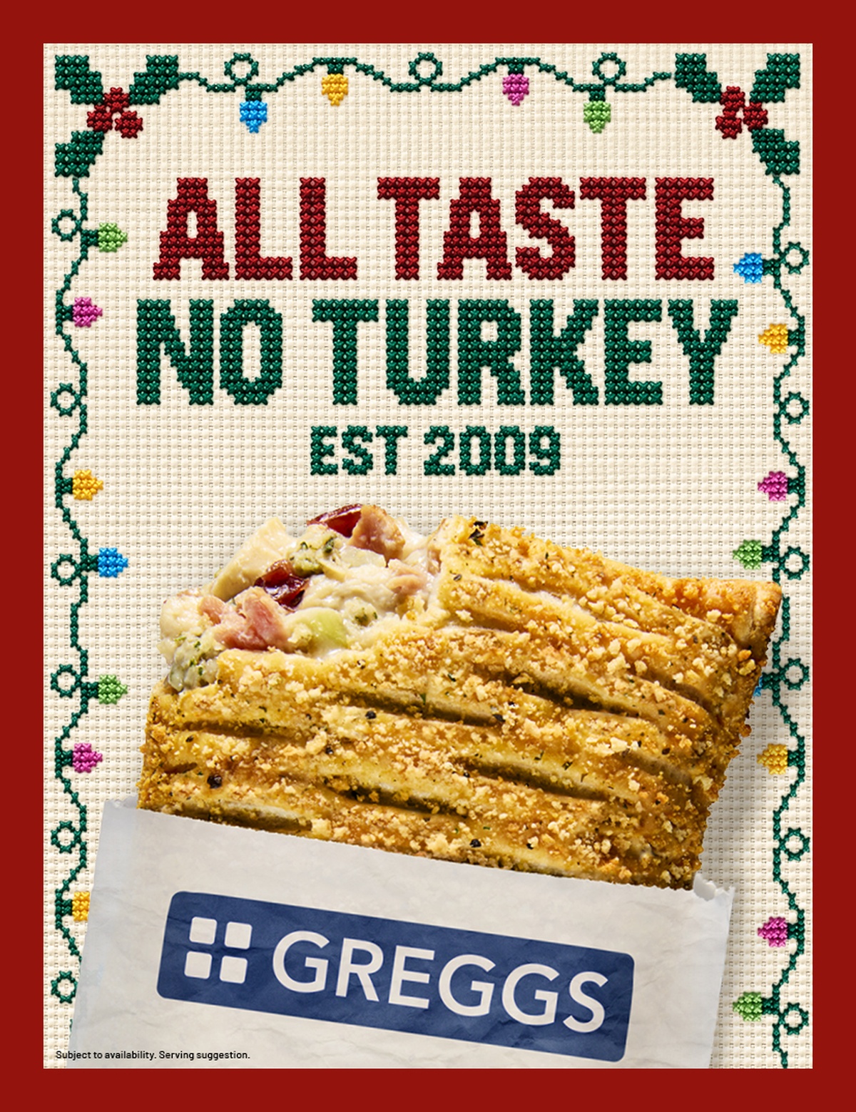 A Festive Bake with fillingvisible, partially wrapped in Greggs packaging, on a cross-stitched background reading "All Taste No Turkey Est 2009."