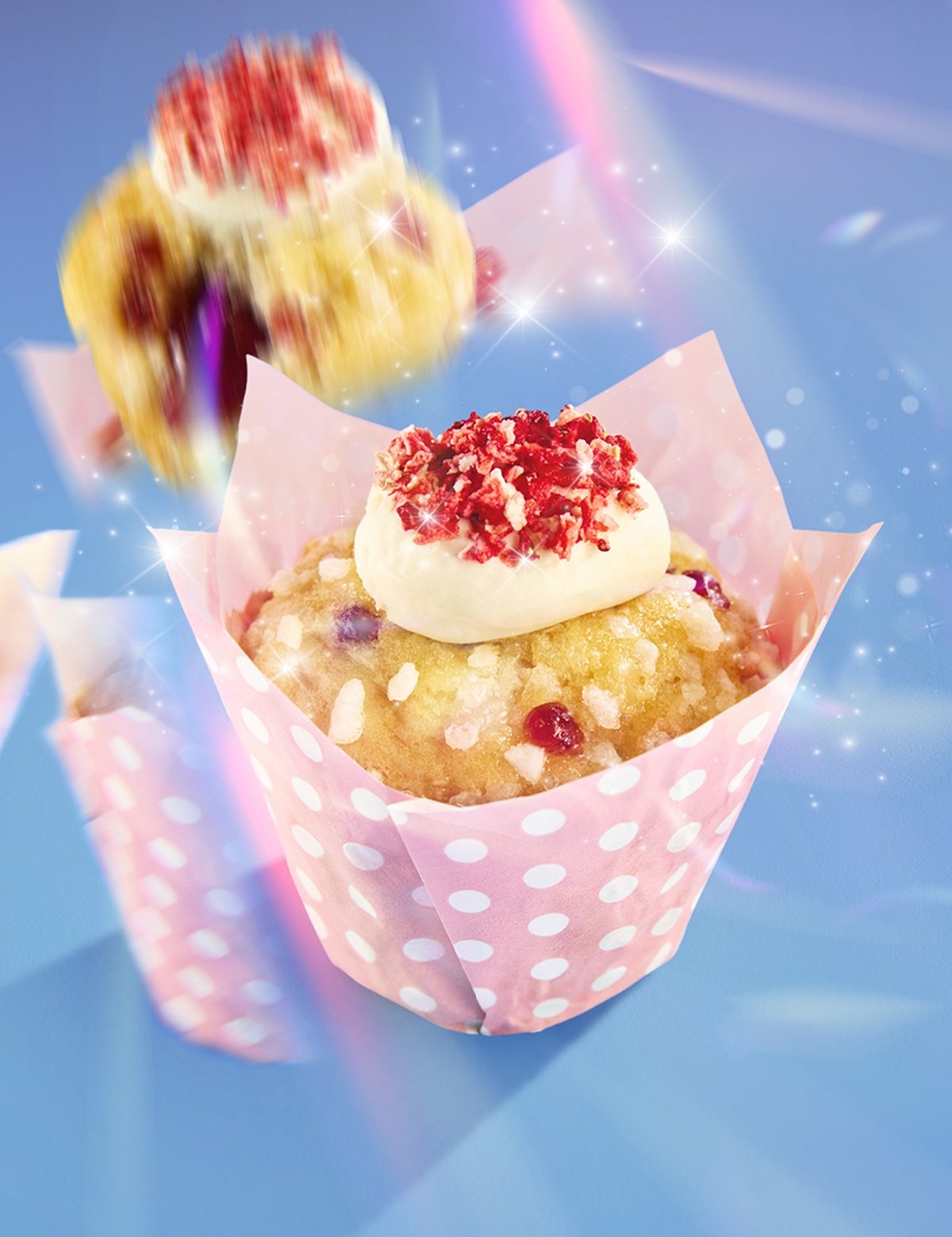 A Strawberry and Cream Muffin in a pink and white polkadot wrapper on a blue background with a prismatic effect