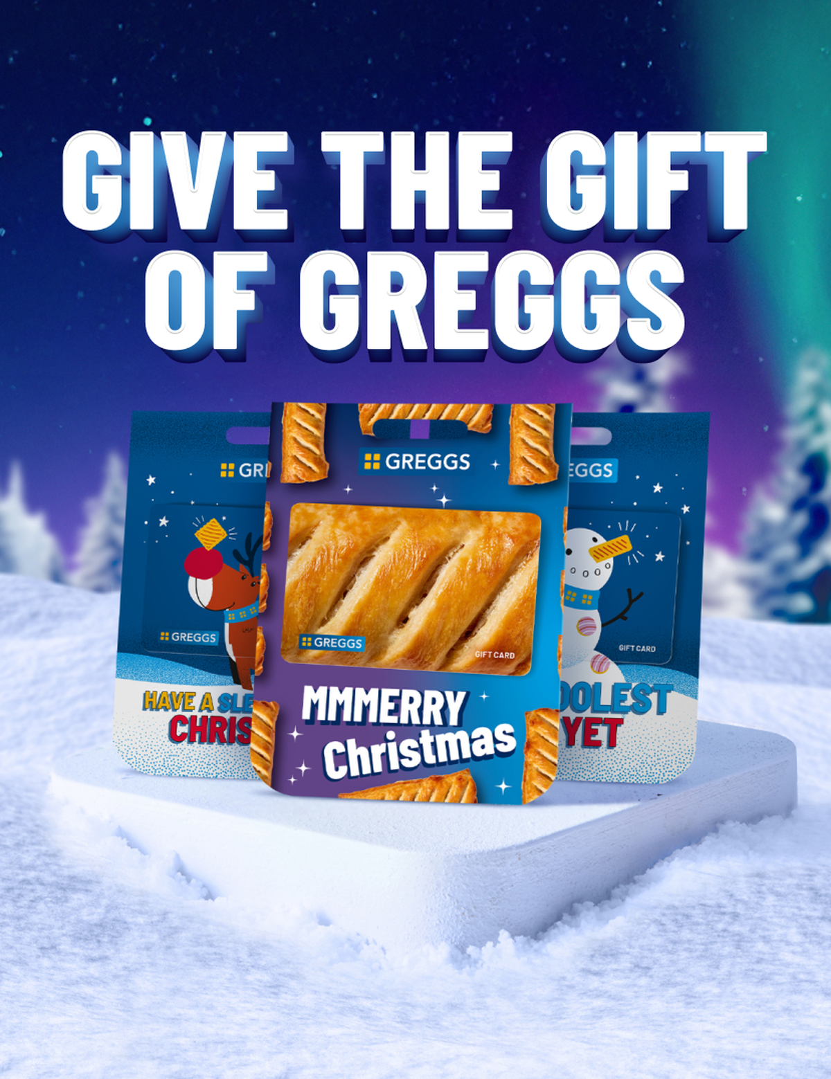 Festive Greggs gift cards on snow, featuring Christmas designs with a reindeer and snowman under a starry twilight sky.