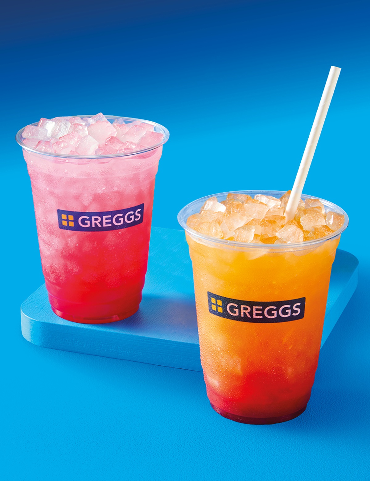 Two cherry iced drinks on a blue gradient background with dramatic shadows and vibrant colours