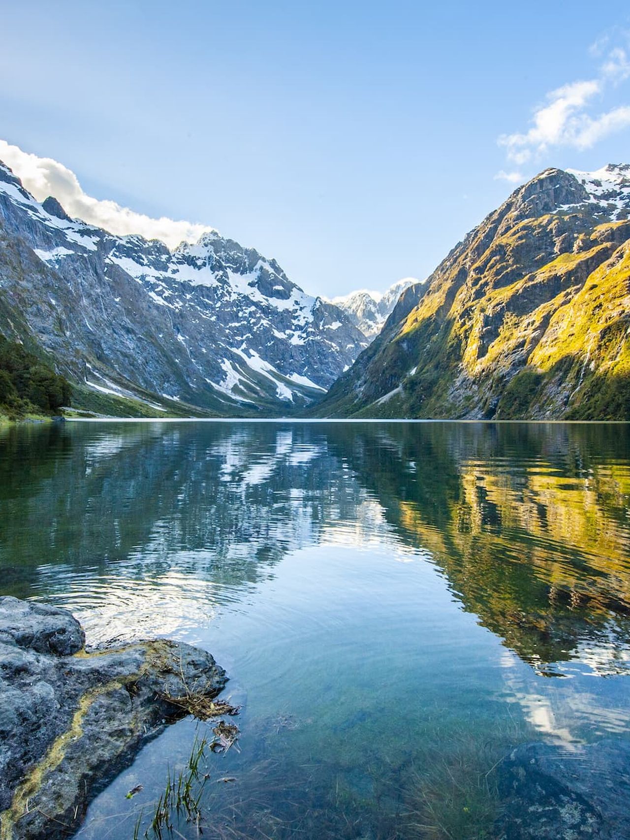 Peaks of Darran Mountains reflecting in Lake Marian, Fiordland national park, New Zealand