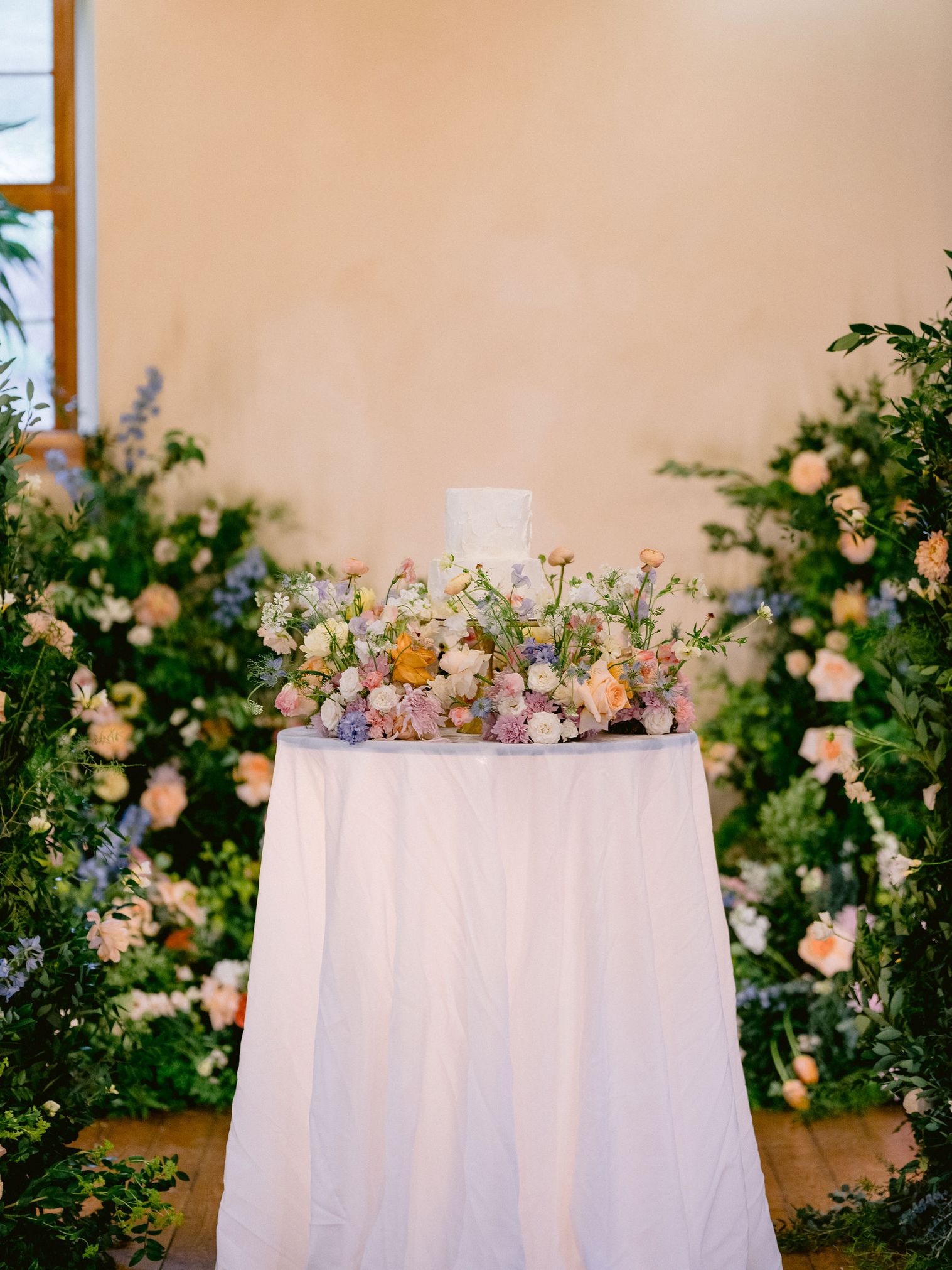 cake meadow with ceremony backdrop florals