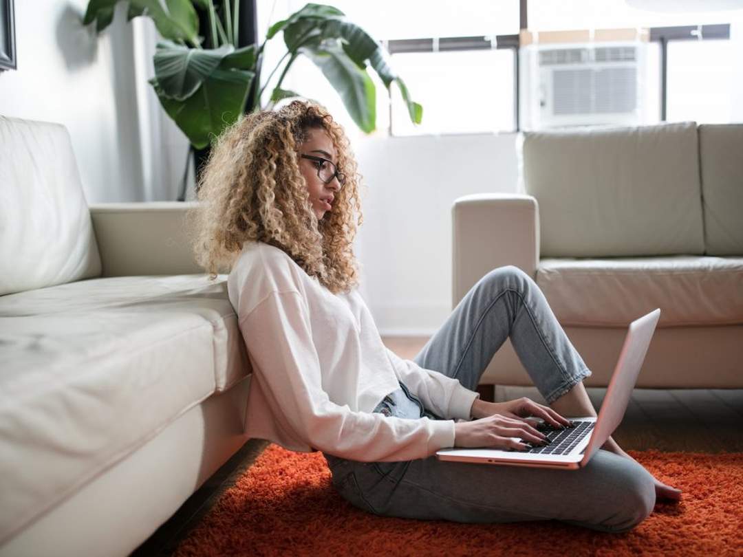 Woman with laptop sitting on the floor
