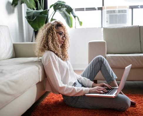 Woman with laptop sitting on the floor