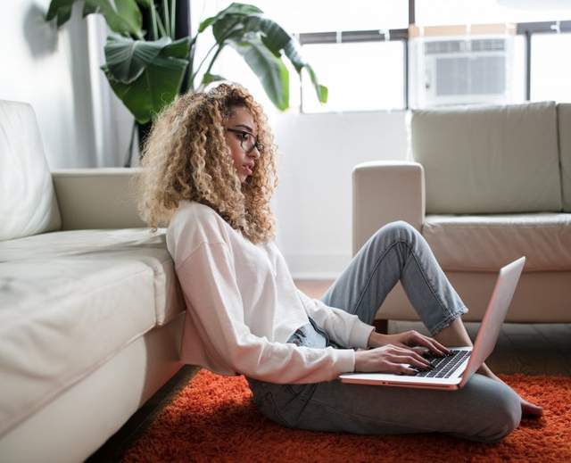 Woman with laptop sitting on the floor