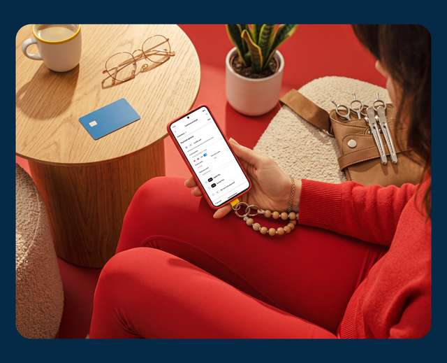 A client choosing how to pay for a salon appointment on their phone, card and glasses on the table