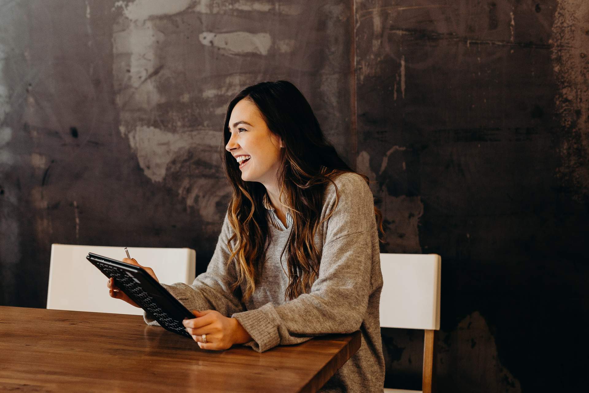 Smiling woman with tablet wearing sweater 
