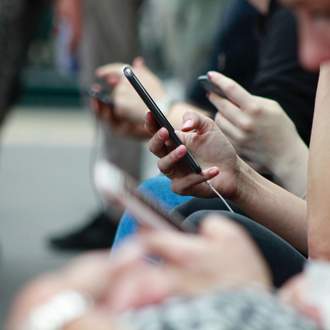 personne avec un téléphone portable qui vient de recevoir un SMS