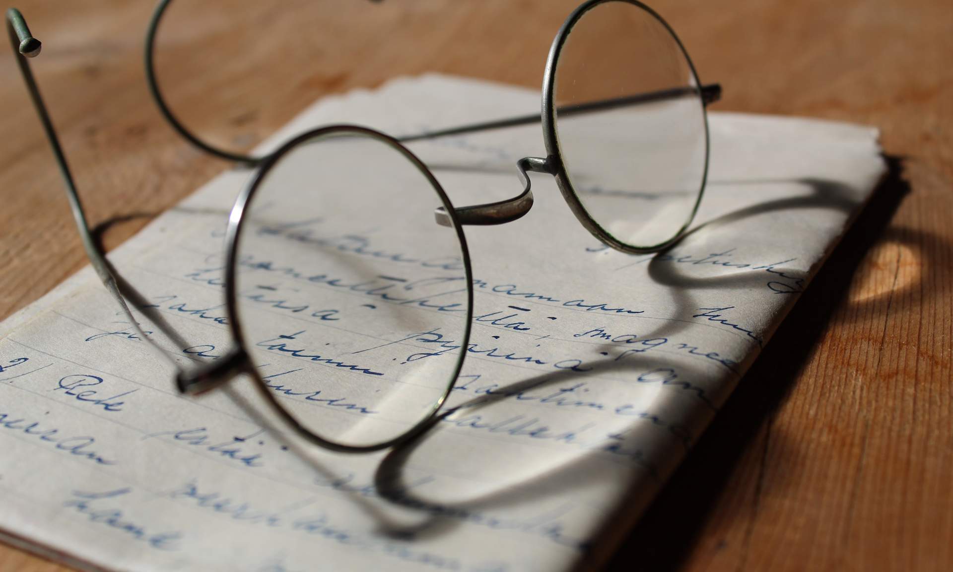 Image of a pair of glasses sitting on a piece of paper on a table