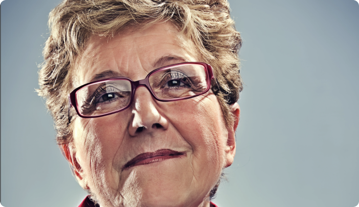 Close up of older woman with red framed glasses smiling