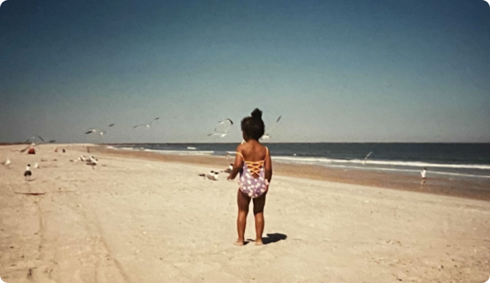 Female toddler facing the horizon at the beach