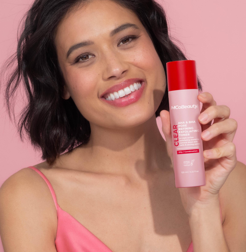 Woman displaying MCO Beauty AHA & BHA Pore Refining Exfoliating Toner, highlighting clearer pores and smoother skin