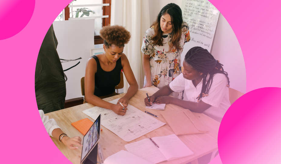 Team collaborating around a table reviewing documents and plans during a client delivery session